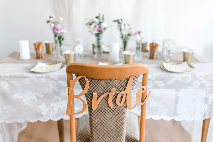 Das selbstgemachte Girlanden-Stuhlschild "Bride" macht den Platz der Bride-to-be zu etwas Besonderem (c) Carina Plößl Fotografie 