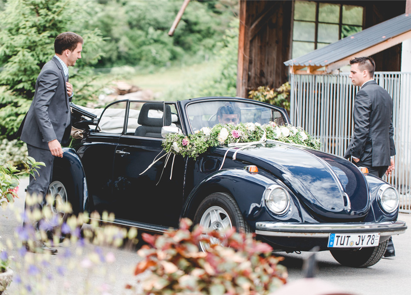 Ein dunkelblaues Käfer Cabrio als Hochzeitsauto - passend zur Vintage-Hochzeit und zum Jackett des Bräutigams!
