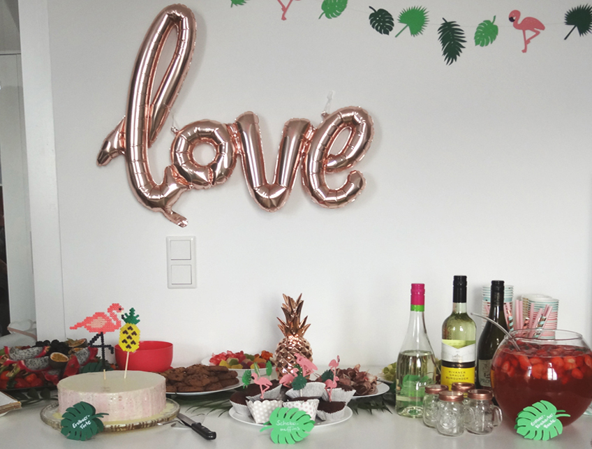 Der "love"-Schriftzug in glänzendem Roségold fügt sich super schön in die tropische Kulisse ein. © Steffi's Hochzeitsblog